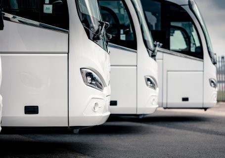 three white coaches parked in a row